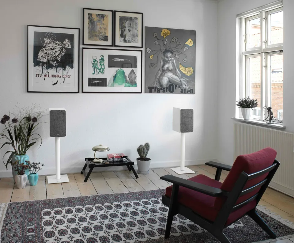 Wohnzimmer mit zwei hellen Regallautsprechern auf Ständern