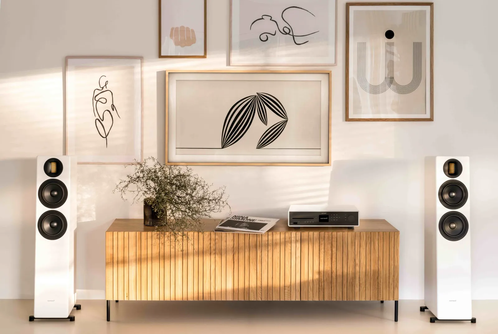 Weiße Standlautsprecher mit Audiogerät auf einem Holz-Sideboard