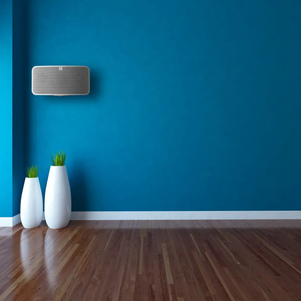 Kleiner Bluesound-Lautsprecher an einer blauen Wand