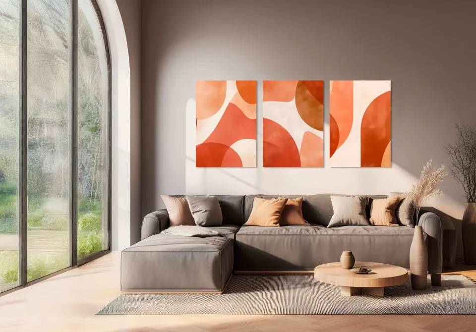 Wohnzimmer mit drei bedruckten Akustikbildern an der Wand über dem Sofa