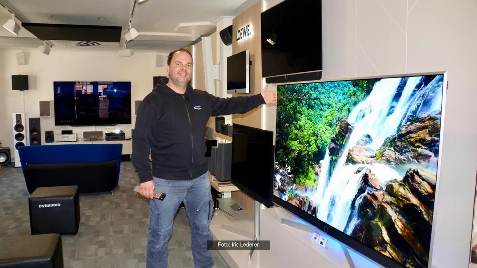 Matthias Drössler im TV-Showroom in Hersbruck neben einem Loewe-Fernseher