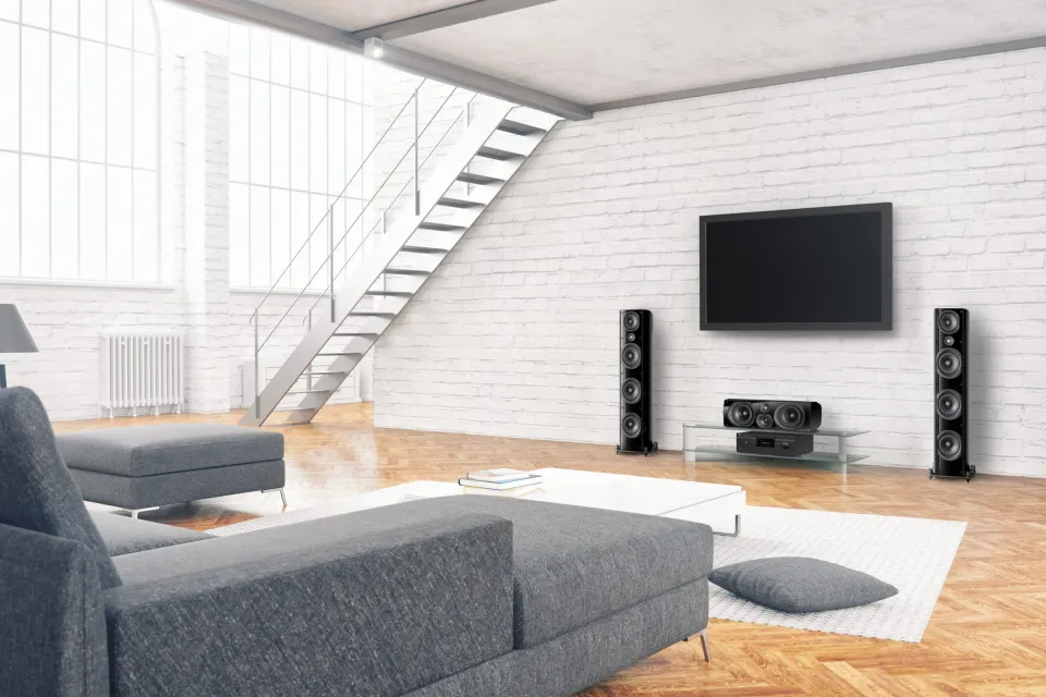 Loft-Wohnzimmer mit Wandfernseher und Standlautsprechern