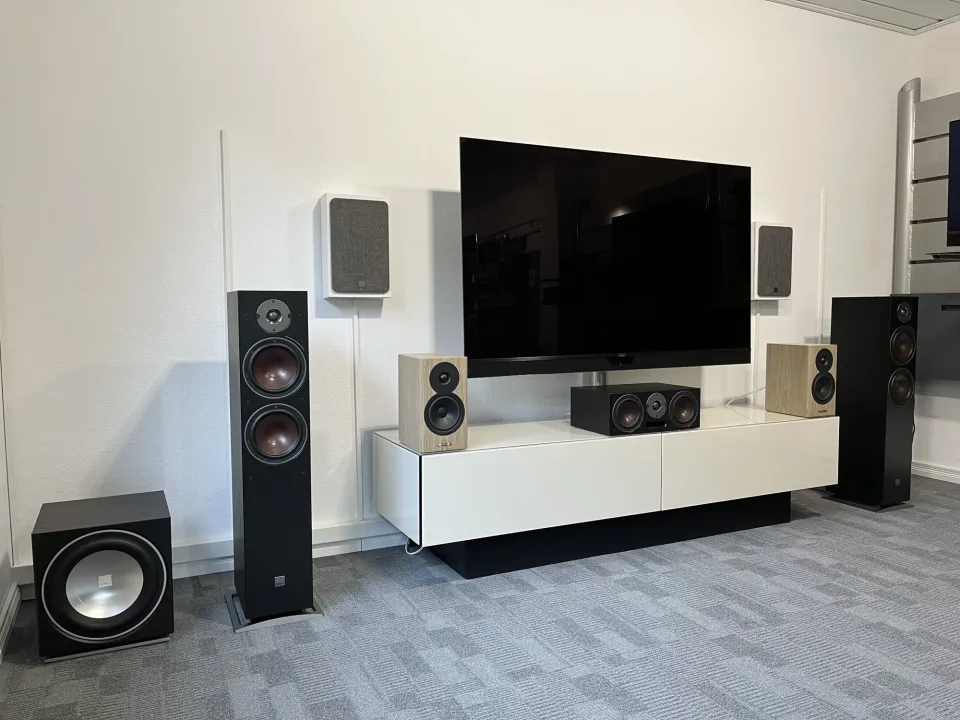 Heimkino-Aufbau im Showroom mit Wandfernseher, Standlautsprechern, Center und Subwoofer