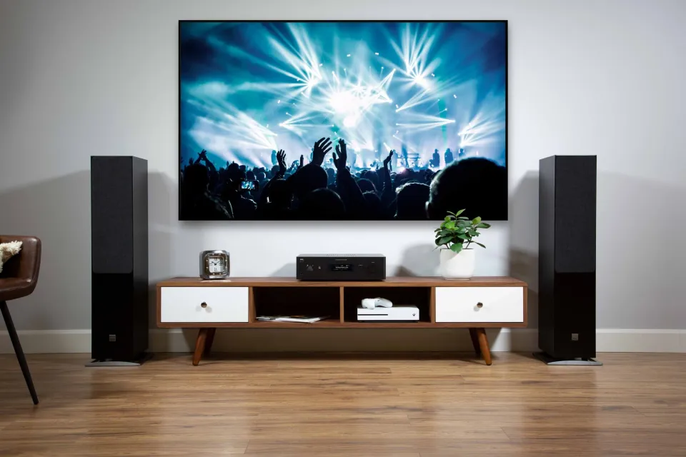 Wohnzimmer mit Fernseher, zwei Standlautsprechern und NAD-Gerät auf dem TV-Möbel